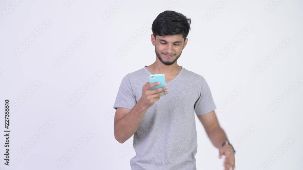 Young stressed bearded Indian man using phone and getting bad news Young stressed bearded Indian man using phone and getting bad news
