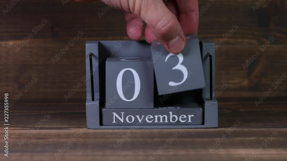 03 setting date on wooden cube calendar for November months.