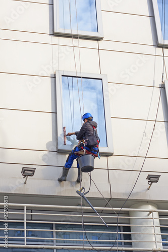 Window washer on a high building. Man washing windows  at height.