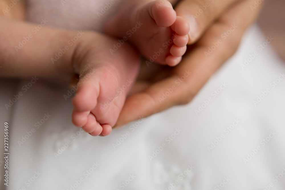 feet newborn in the arms of the mother. feet of a newborn baby. little foot