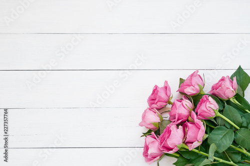 Bouquet of pink roses on white wooden background. Top view, copy space.