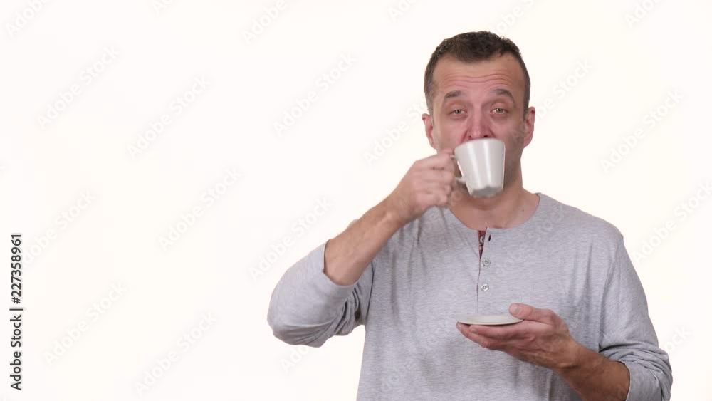 Man sleepy tired holding coffee cup drinking giving thumb up. Male having hard morning, getting energy, isolated on white. Slow motion Man sleepy tired holding coffee cup drinking giving thumb up. Male having hard morning, getting energy, isolated on white. Slow motion