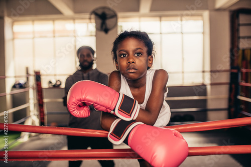 Girl wearing boxing gloves standing near a boxing ring © Jacob Lund