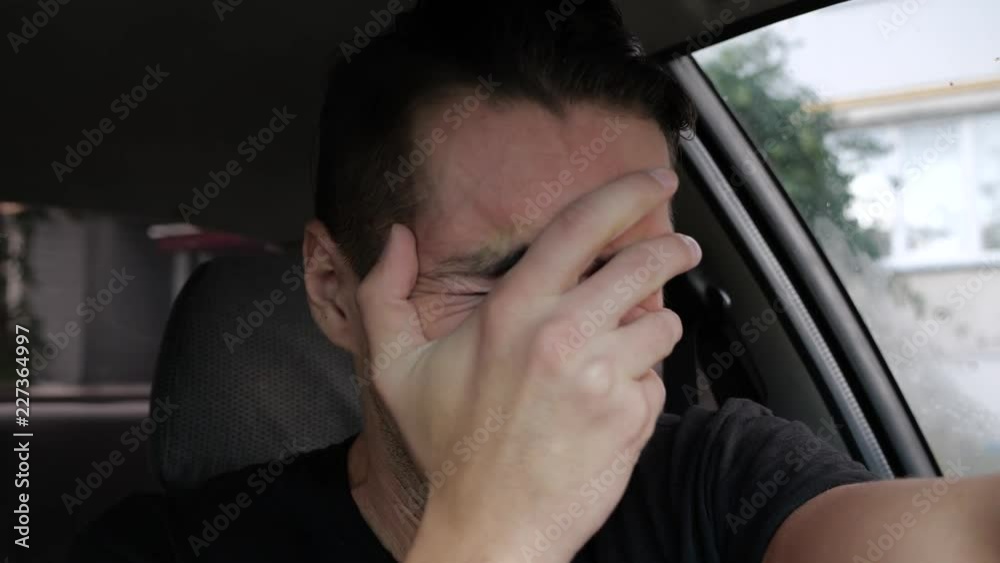 Sad desperate man crying in the car