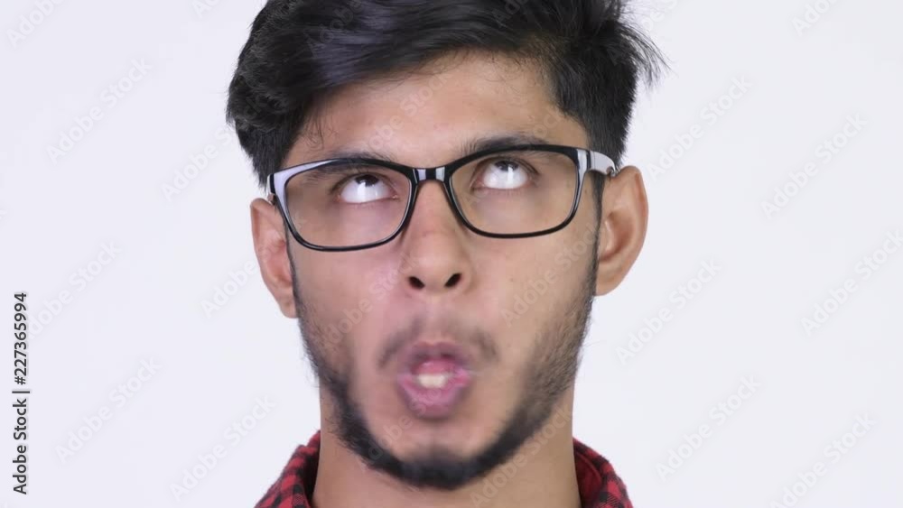 Young happy bearded Indian hipster man making funny faces