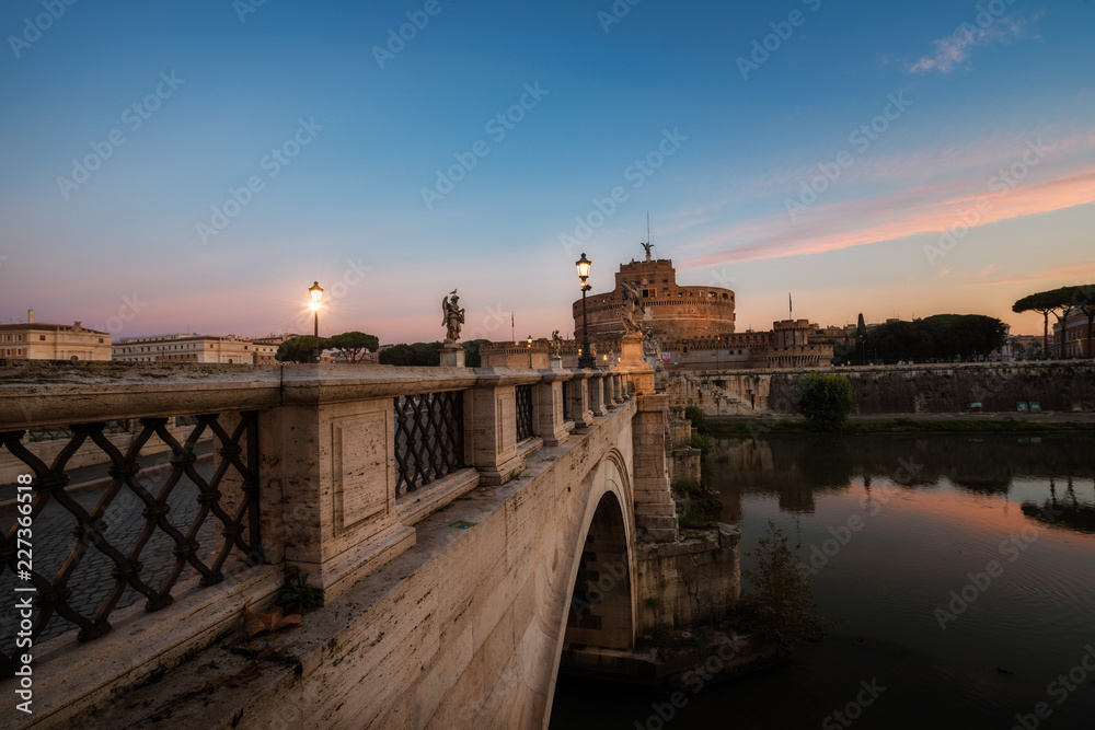 Castle Sant Angelo, bridge Sant Angelo and river Tiber in the rays of sunrise in Roma, Italy.