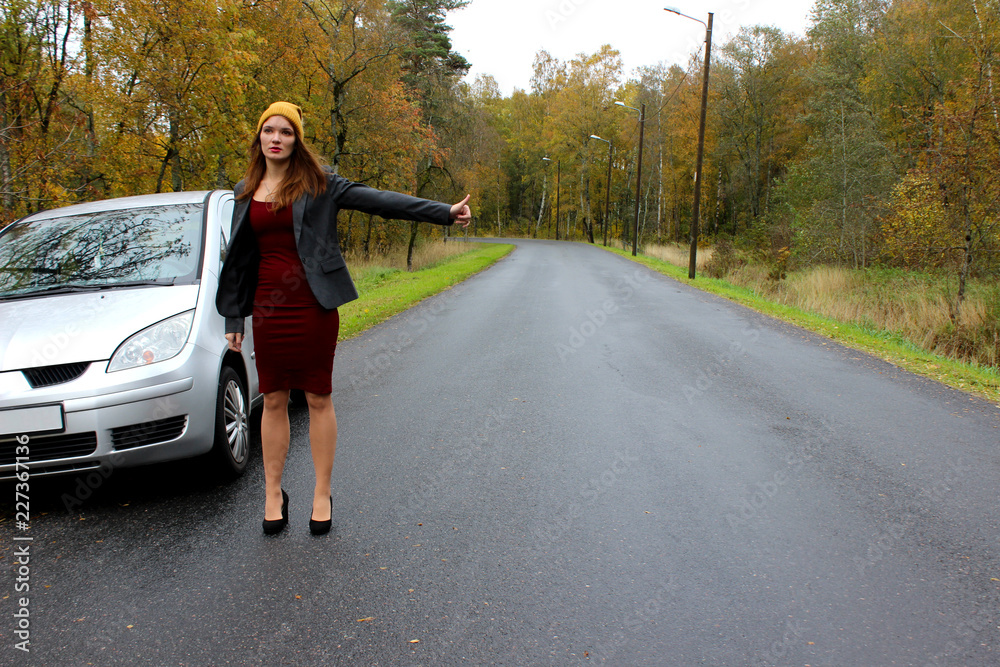 the autumn day the car broke down and the girl in a dress with a hat catches another car to help the autumn day the car broke down and the girl in a dress with a hat catches another car to help