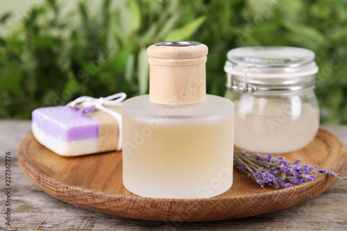 Fototapeta Naklejka Na Ścianę i Meble -  Natural herbal oil and lavender flowers on table against blurred background