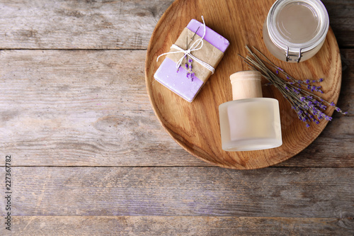 Fototapeta Naklejka Na Ścianę i Meble -  Flat lay composition with natural herbal oil, soap and lavender flowers on wooden background. Space for text