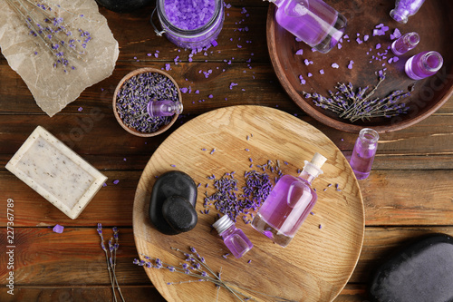 Fototapeta Naklejka Na Ścianę i Meble -  Flat lay composition with natural herbal oil, soap and lavender flowers on wooden background