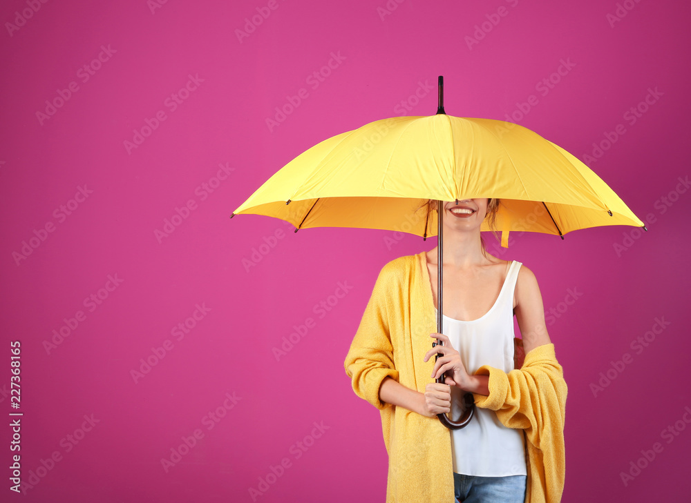 Woman with yellow umbrella on color background. Space for text - obrazy, fototapety, plakaty 