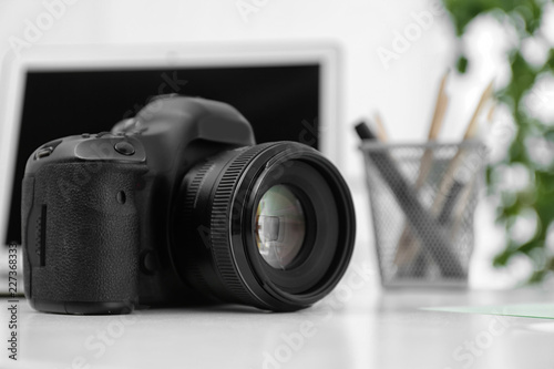 Digital camera on white table. Equipment for professional photographer