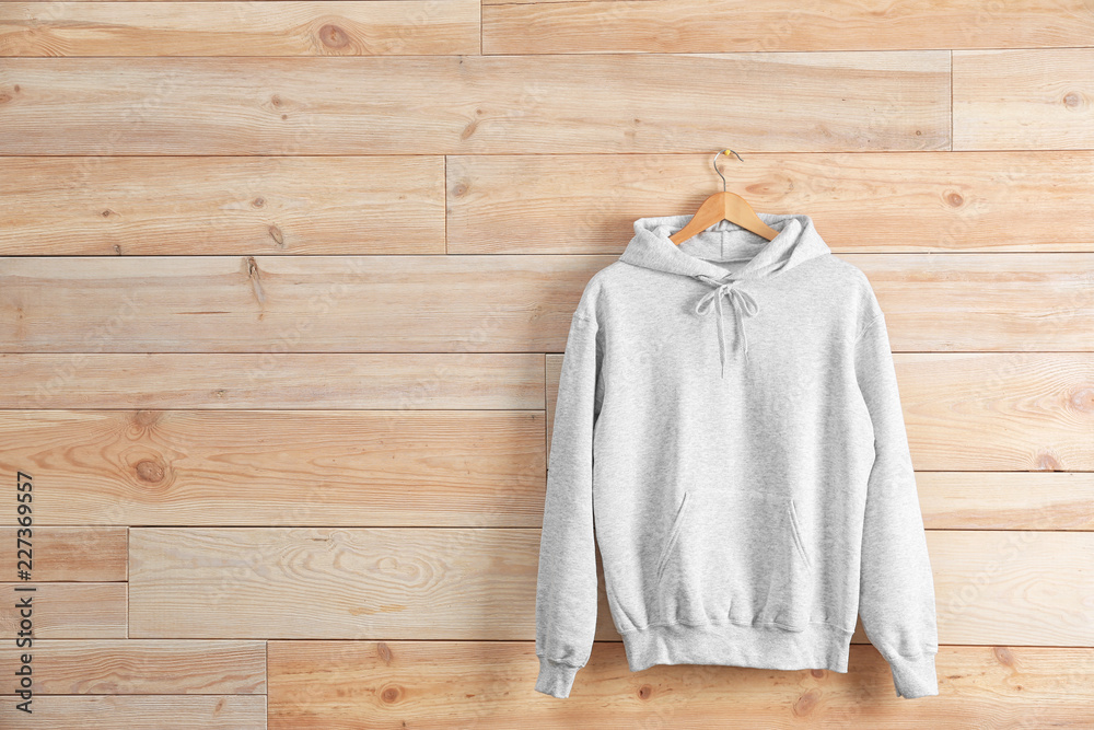 New hoodie sweater with hanger on wooden wall. Mockup for design Stock  Photo | Adobe Stock