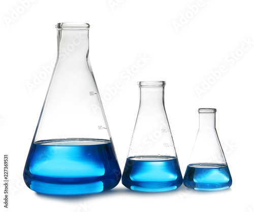 Conical flasks with liquid on table against white background. Laboratory analysis