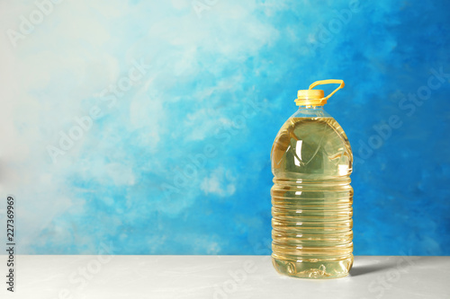 Fototapeta Naklejka Na Ścianę i Meble -  Bottle of oil on table against color background. Space for text