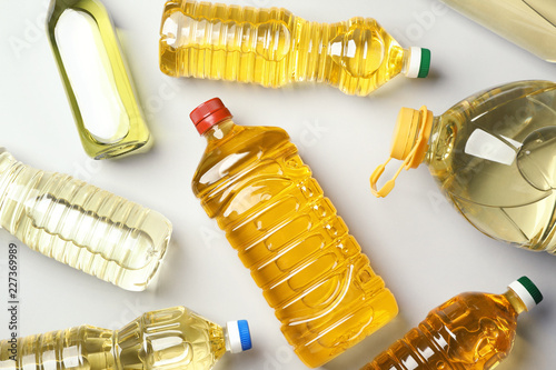 Bottles of oils on light background, top view
