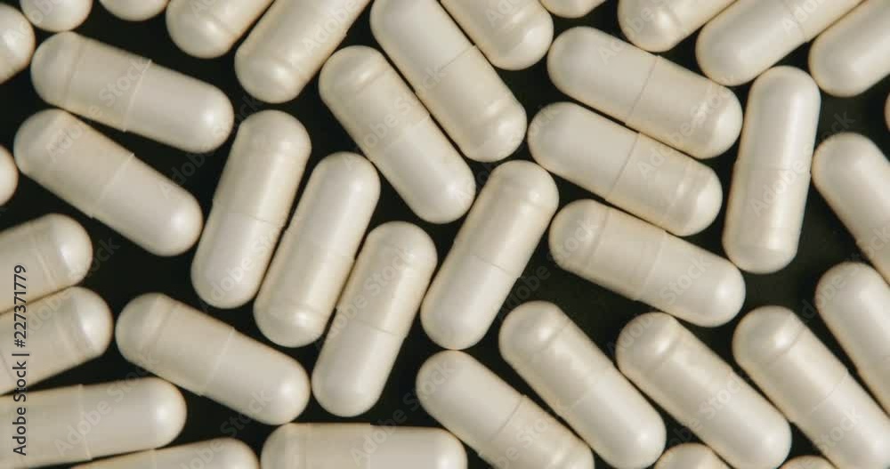 Medical white pills rotation on black background