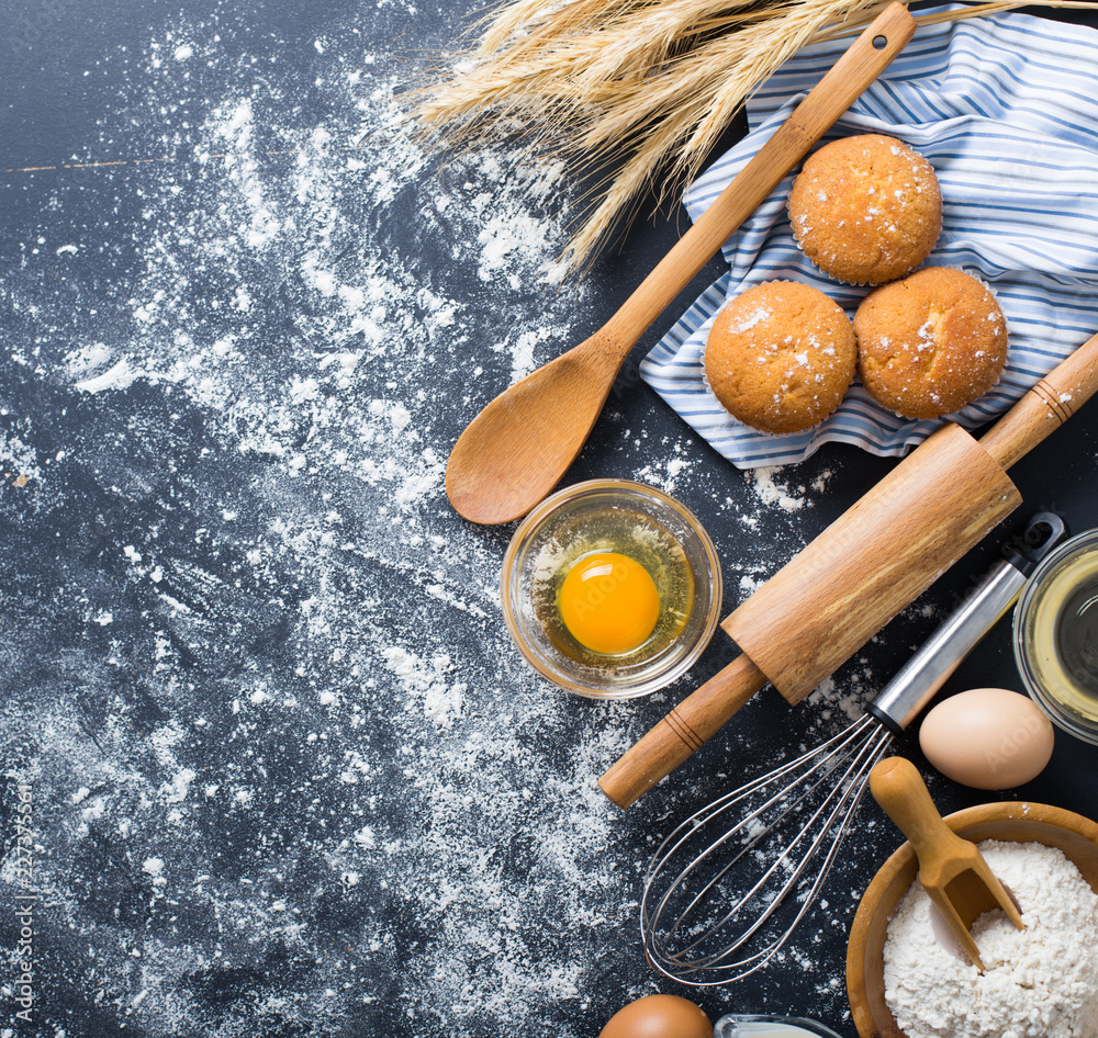 Baking ingredients. Bowl, eggs, flour, eggbeater, rolling pin and eggshells on black chalkboard from above. Baking ingredients. Bowl, eggs, flour, eggbeater, rolling pin and eggshells on black chalkboard from above.