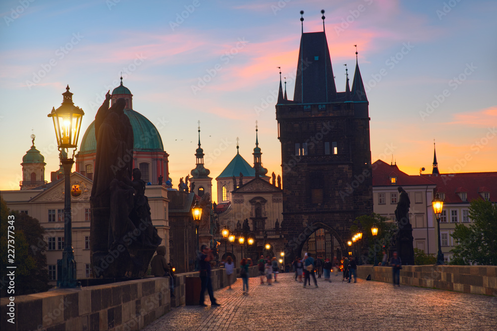 Charles Bridge at dawn: silhouettes of Old Bridge Tower and spires of Old Prague on a sunrise