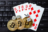 Bitcoins, cards and dices on keyboard. Cryptocurrencie gambling concept
