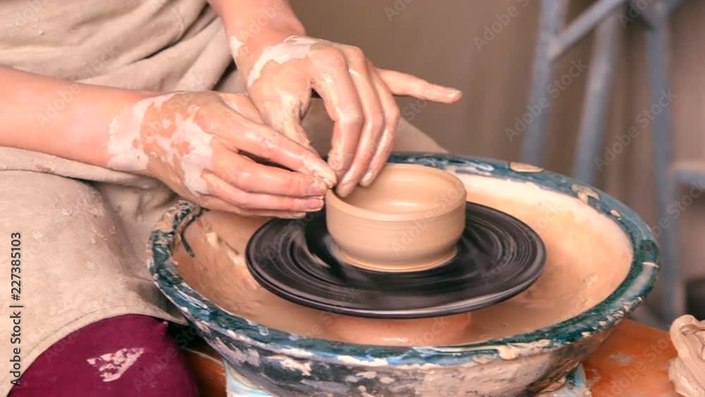 Woman girl with her hands dub wall jug, which she sculpts out of clay on circle. Workshop on sculpt white clay closeup. Making ceramic products. Artistic creative work Art. Clay modeling close skills Woman girl with her hands dub wall jug, which she sculpts out of clay on circle. Workshop on sculpt white clay closeup. Making ceramic products. Artistic creative work Art. Clay modeling close skills