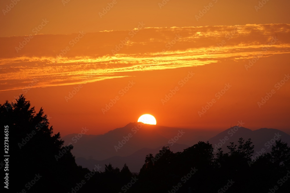 オレンジ色に輝く日没の太陽