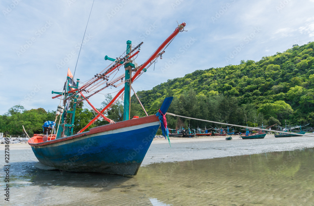 Fototapeta premium Blue Fishing Boat on Sea Sand with Green Mountain at Khao Kalok Beach Thailand