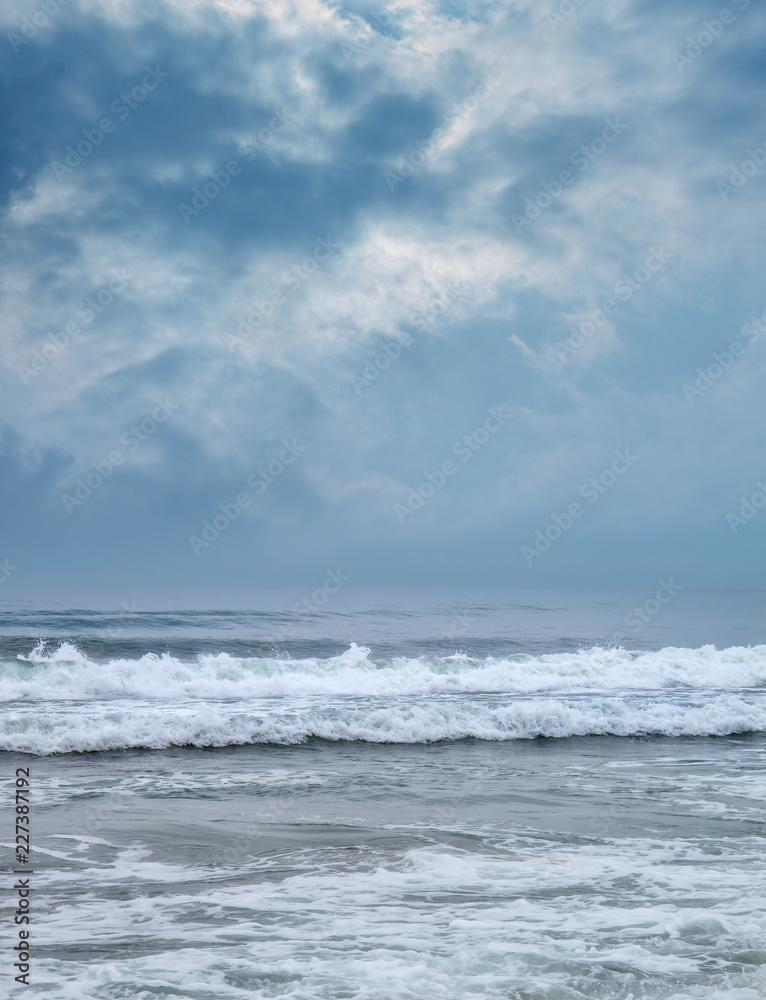 Landscape image os sea with waves over storm sky