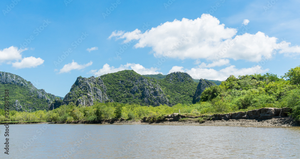 Stone or Rock Mountain or Hill with Green Tree and Blue Sky and Water and Cloud