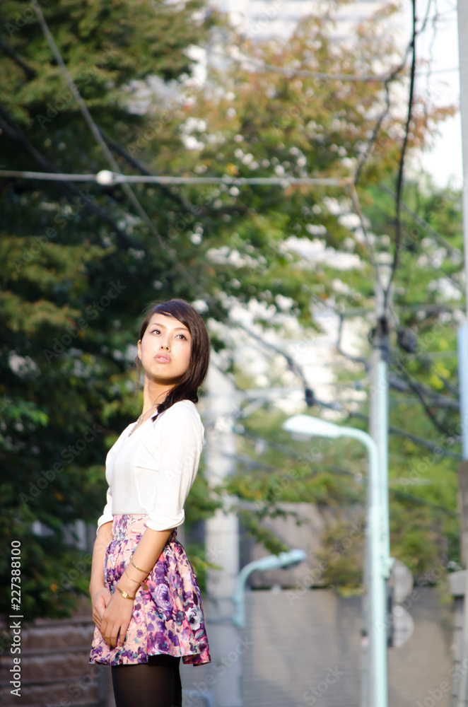 Japanese Girl poses on the street in Nakameguro, Japan. Nakameguro is a town located in the nice area of Tokyo.