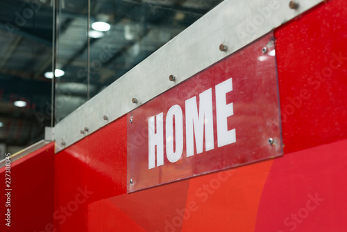 Sport sign `Home` on the wall in the ratiocination center. The sign is transparent with white characters on the red background. photo