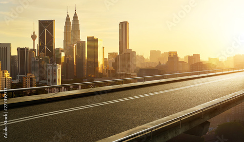 Empty asphalt flyover  road with modern cityscape skyline   sunrise scene .
