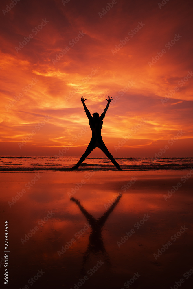 Silhouette of a man Jumping in the air on a beach