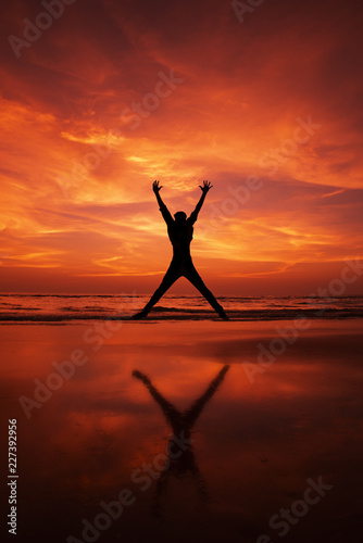 Silhouette of a man Jumping in the air on a beach