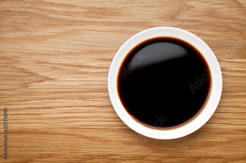 Dish of soy sauce on the wooden table  Top view.