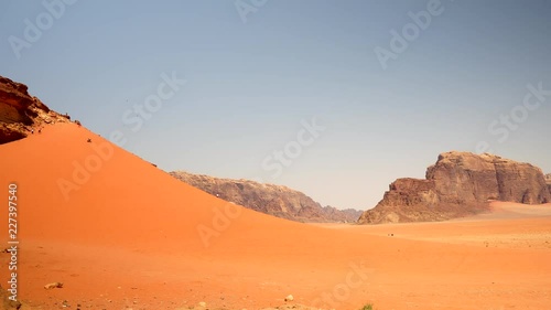 timelapsed People running on huge sand dune in Jordan Wadi Rum photo