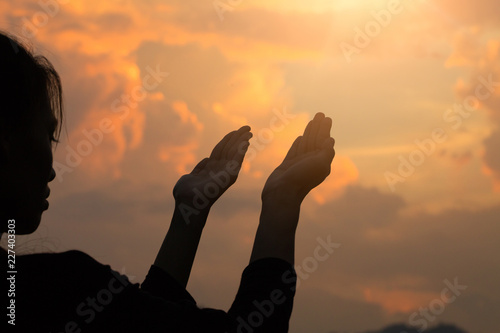 Silhouette of woman hands praying to god with the bible. Woman Pray for god blessing to wishing have a better life. Christian life crisis prayer to god.