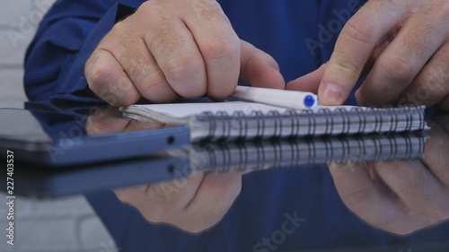 Businessman in Office Using a Pocketbook for Writing Information
