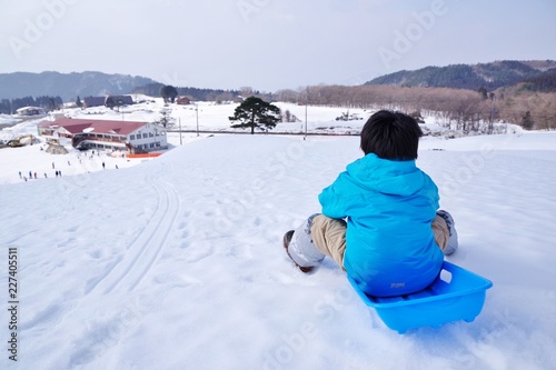 スキー場でそり遊びをする子供