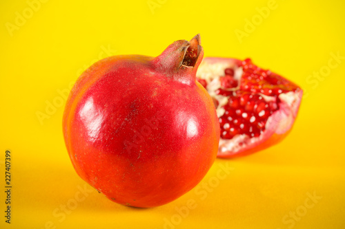 гранат свежий фрукт раскрытый лежит на ярком фоне 