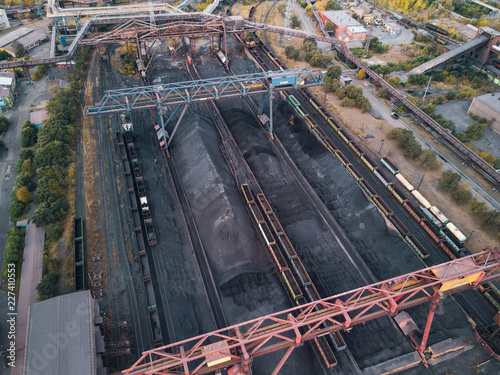 Drone faerial view of moving train with production for export on the huge manufacturing site of one of the world largest steel plant with infrastructure and logistical system;limited natural resources