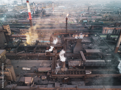 View point of smoking chimney with yellow white black colors; burning fire and smoke coming out of factory pipes; industrial zone with dirty air and fog; polluted area; unhealthy hazardous production