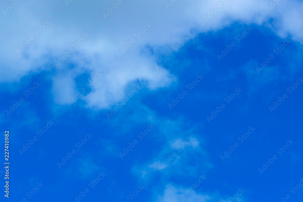 Blue sky background with tiny clouds. White fluffy clouds in the blue sky.