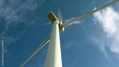 Closeup of wind turbine in operation against blue sky. photo