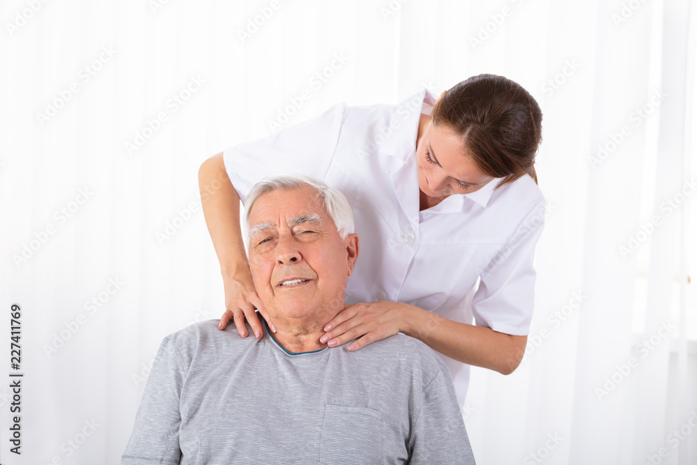 Obraz premium Physiotherapist Massaging Senior Man's Shoulder