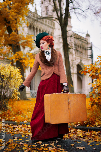 Beautiful woman face in the hat and red hair with luggage autumn travel