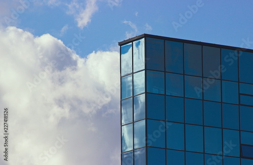top of a skyscraper next to the clouds and sky