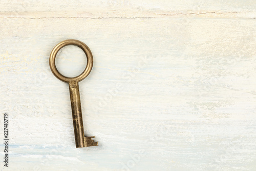 A top shot of a vintage key on light background with a place for text