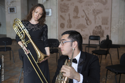 Two musicians playing on wind instruments