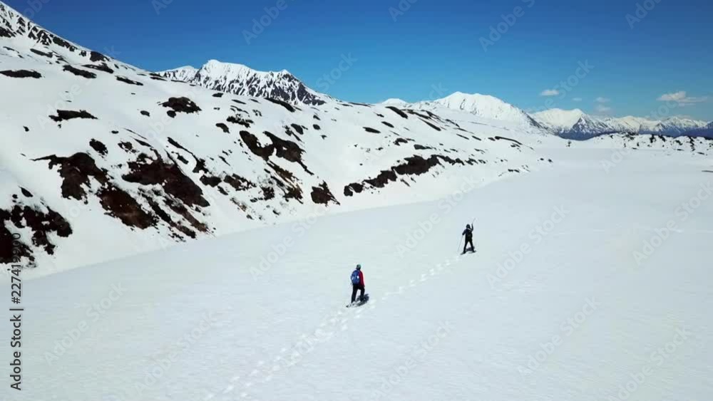 Aerial View Panning Around Two Snowshoe Hikers Aerial View Panning Around Two Snowshoe Hikers
